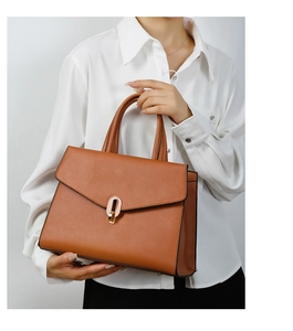 Brown lychee leather handbag featuring a rose gold oval clasp lock detail