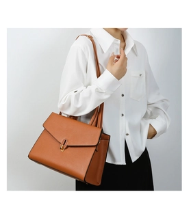 Brown lychee-grain faux leather tote bag with gold oval twist lock shown on model
