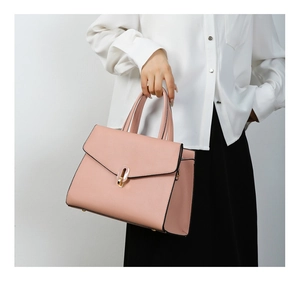 Detail of pink fashion handbag with fine leather texture and golden metal buckle