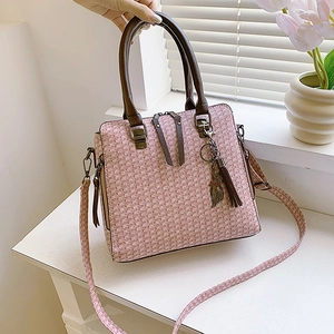 Pink tweed crossbody bag with leather handles and a cute cat tassel charm accessory