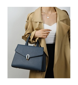 Deep blue lychee leather handbag featuring a stylish oval metal buckle and top handle