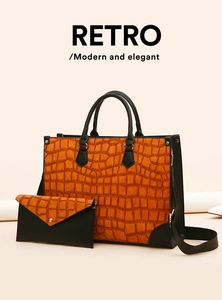 Details des orangefarbenen Sets aus Krokodil-Prägung-Tote und schwarzer Clutch