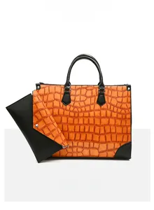 Detail der orangefarbenen Tragetasche mit Krokodilmuster und passender Umschlagtasche