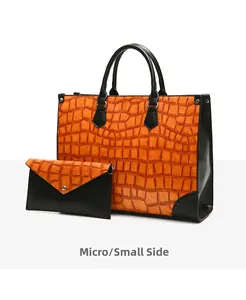 Makro-Seitenansicht von Tragetasche und Clutch mit Krokoprägung im Set in Orange