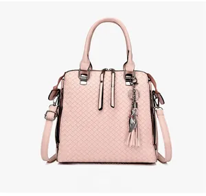 Borsa rosa con motivo intrecciato, ciondolo a forma di gatto, nappe e doppi manici