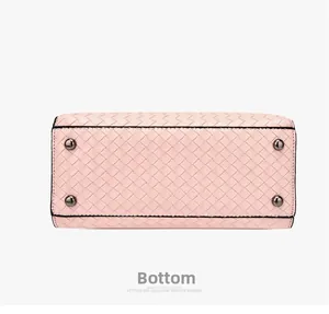 Vista dettagliata del fondo borsa intrecciata rosa con quattro piedini in metallo