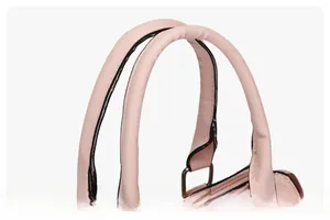 Dettaglio della borsa rosa intrecciata con doppi manici rotondi e anelli a D in metallo argento