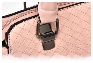 Dettaglio borsa rosa intrecciata con finiture in metallo e manico con rinforzo extra
