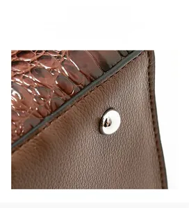 Close-up of crocodile embossed leather texture with silver metal protective stud on base