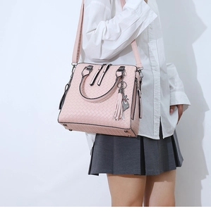 Borsa tote intrecciata rosa con ciondolo a gatto in metallo e dettagli con nappe