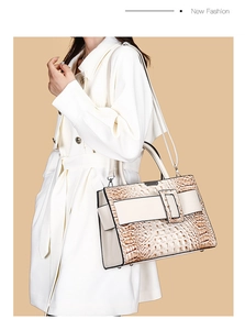 Detail of crocodile pattern shoulder bag with a square buckle on a white trench coat