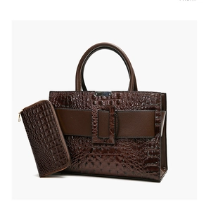Detail of dark brown crocodile embossed tote bag and matching long zipper wallet set