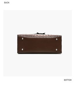 Detail of dark brown handbag bottom with silver metal feet and crocodile pattern leather