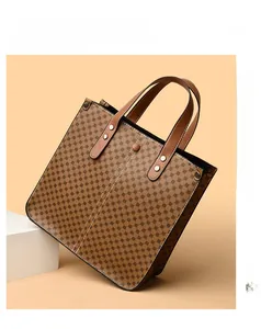 Detail of vintage monogram leather tote bag with brown pattern and metal rivets
