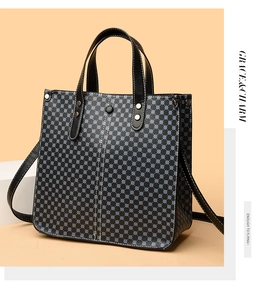 Detail of black tote bag with blue patterns, white stitching and adjustable strap