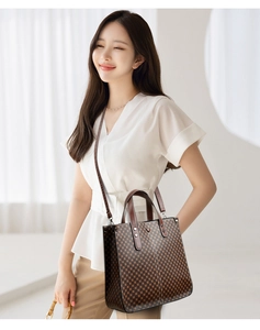 Detailed view of the brown checkerboard tote bag with dual handles and adjustable strap