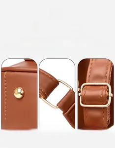 Detail of polished gold-tone hardware and stitching on a brown leather backpack