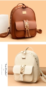 Detail of brown and beige backpacks with gold rivets and decorative tassels in a studio setting