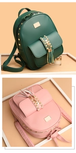 Close-up of matte leather backpacks in green and pink with gold studs and tassel charms