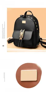 Close-up of golden stud hardware and tassel charm on a black faux leather backpack