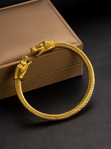 Gros plan du bracelet tête de loup plaqué or 18 carats avec texture torsadée sur boîte