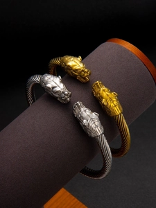 Gros plan détaillé des bracelets câbles à double tête de loup en or et argent