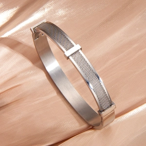 Silver mesh stainless steel bracelet on champagne silk showing refined metal texture