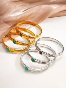 Gros plan de joncs vintage en acier titane avec incrustations de malachite et turquoise