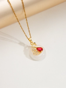 Détail macro du collier pendentif cygne avec base en jade blanc et pierres rouges