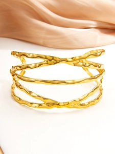 Détail macro du bracelet en acier plaqué or 18k avec texture ondulée irrégulière