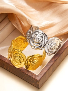 Dettaglio dei bracciali rigidi a rosa 3D in placcatura oro e argento su seta