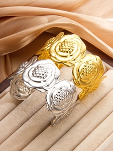 Dettaglio di bracciali a forma di rosa in oro e argento con finitura lucida in titanio 18k