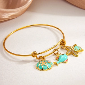 Golden sea shell and starfish charm bracelet with teal enamel and pearl details