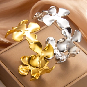Bracelets trèfle en or 18k et argent poli sur une boîte à bijoux de luxe raffinée