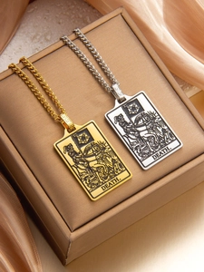 Detailed engraving of Death tarot card pendant with Cuban chain on silk fabric