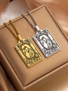 Detailed close-up of gold and silver tarot card necklaces on a luxury silk backdrop