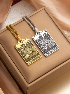 Macro detail of gold and silver tarot The Empress pendants on Cuban link chains