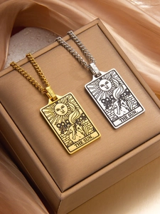 Macro detail of gold and silver tarot The Sun pendants on elegant Cuban chains