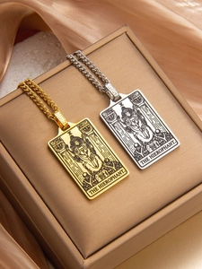 Close-up of gold and silver Hierophant Tarot card pendants with detailed metal engraving