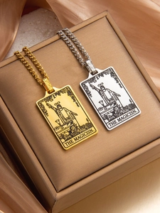 Close-up of gold and silver tarot necklaces with magician pendant on Cuban chain