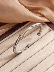 Detail of twisted cable cuff bracelet in silver and gold on velvet display