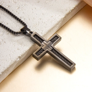 Collier croix noir pour homme avec texture de câble et chaîne box sur fond pierre