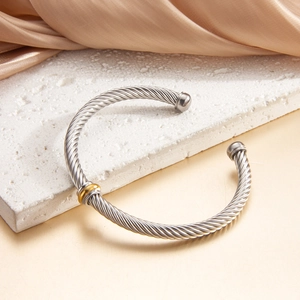 Adjustable twisted cable wire bracelet in two-tone silver and gold stainless steel finish
