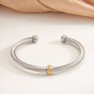 Silver twisted cable cuff bracelet with gold ring detail and spherical ends