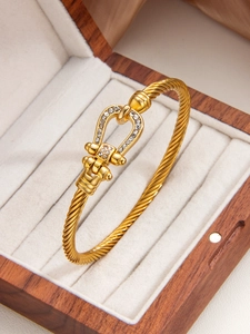Dettaglio di un bracciale a ferro di cavallo placcato oro 18k con diamanti in legno