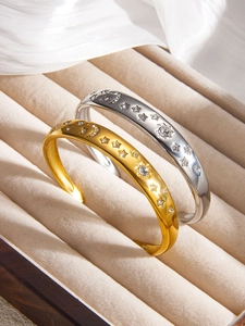 Détail de joncs lune et étoile or et argent avec cristaux sur plateau à bijoux en velours