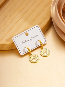 Macro detail of gold Roman numeral earrings with pavé crystals on a luxury display card
