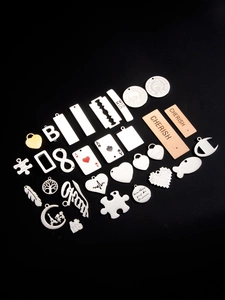 Detailed macro view of assorted stainless steel charms in heart, tree and tower shapes