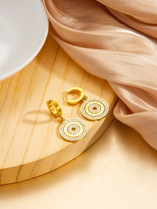 Macro detail of gold Roman numeral earrings featuring micro-pave diamonds on silk