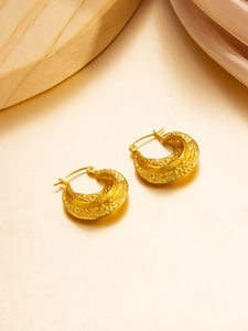 Detail of 18k gold PVD plated hoop earrings with hammered metal texture on silk